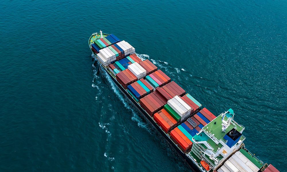 An aerial view of a container ship in the ocean.